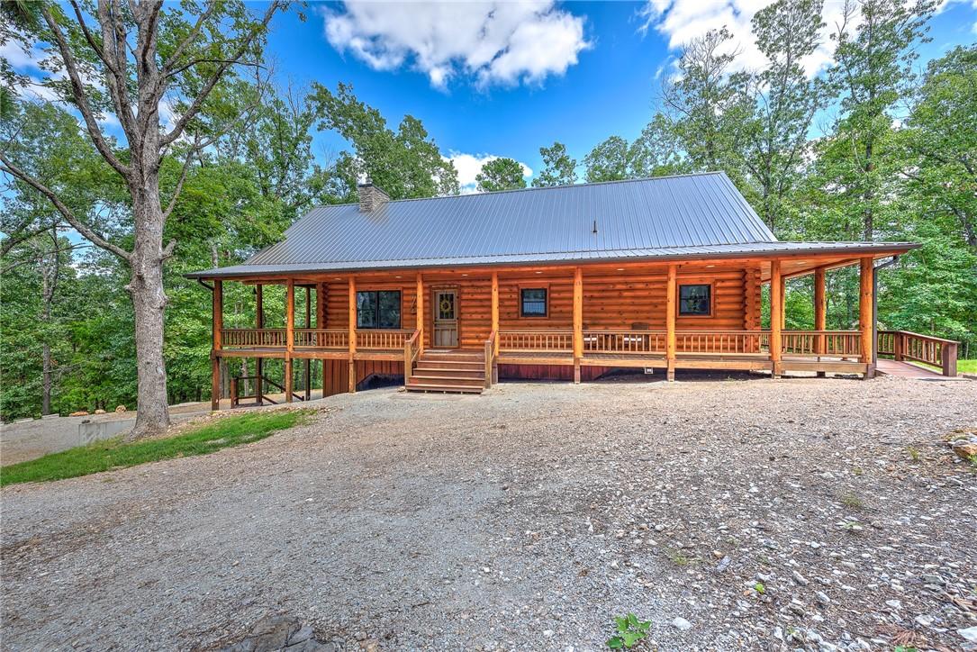Image 4: Log cabin with log siding, a metal roof, a large p
