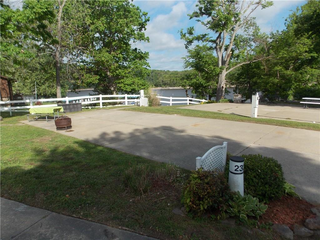 Image 3: Paved lot with white fencing and mature trees