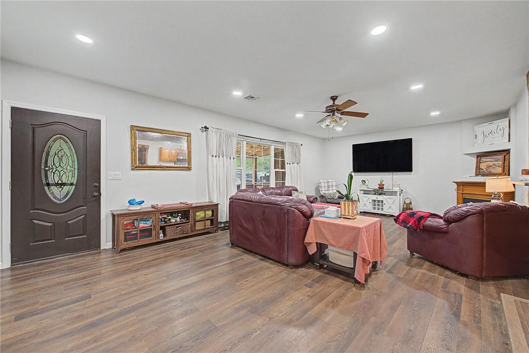 Image 2: Spacious living area featuring wood-finish floorin