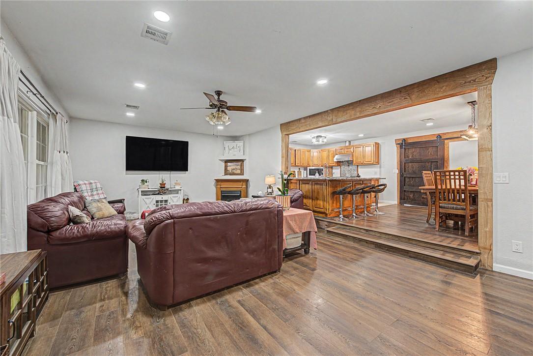 Image 3: Spacious living area featuring wood-finish floorin