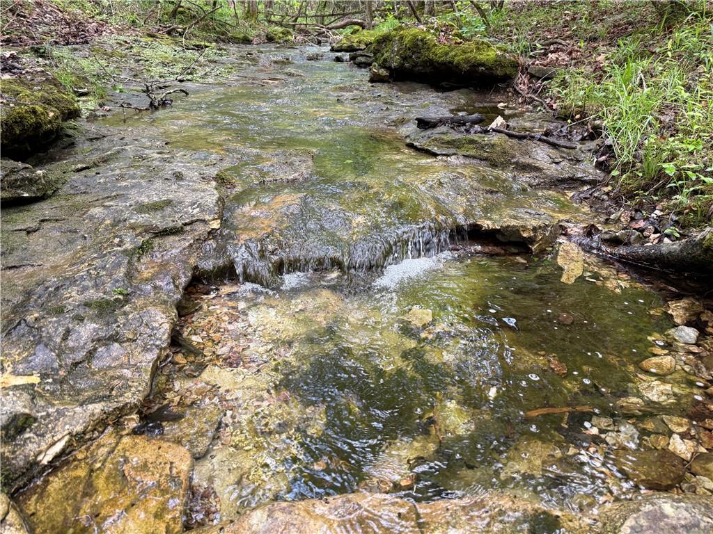 Image 3: Natural water feature with rock formations and sur