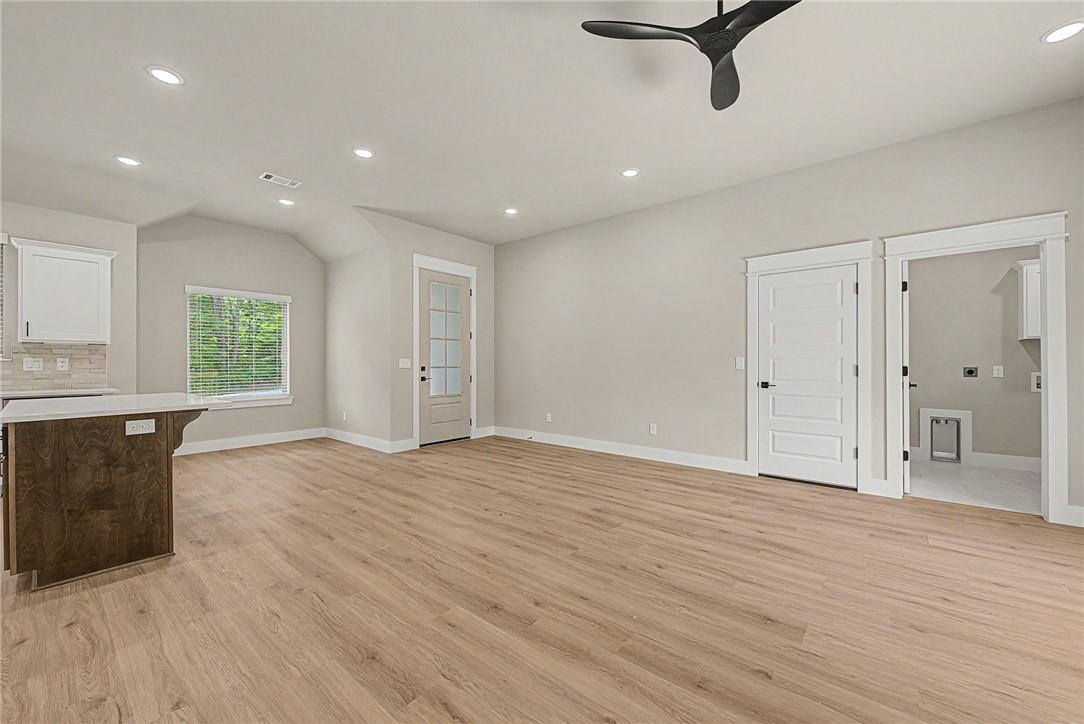 Image 4: Spacious open-concept living area featuring wood-f