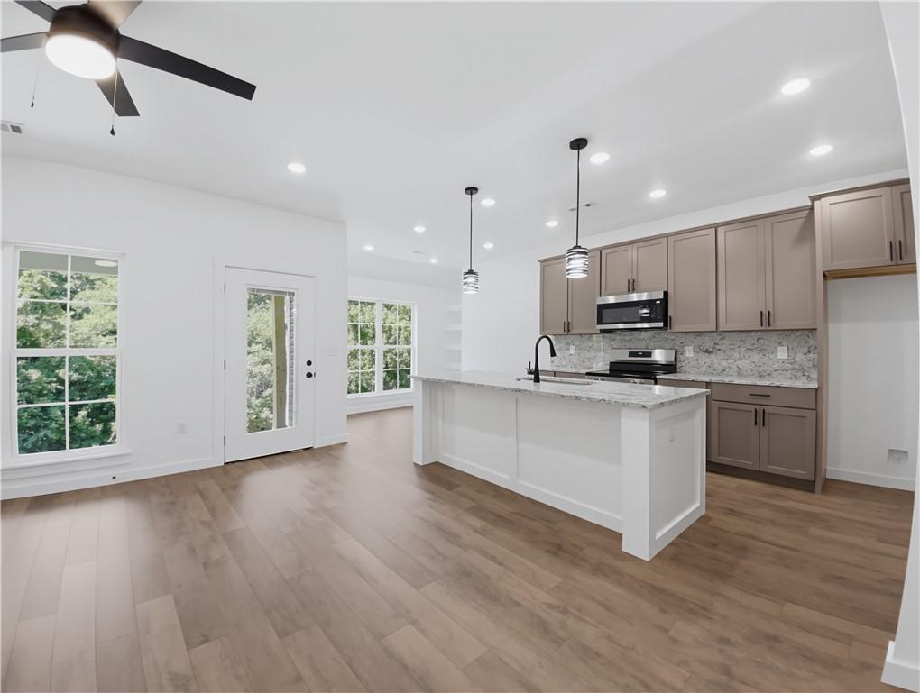 Image 4: Open-concept kitchen and living area featuring woo