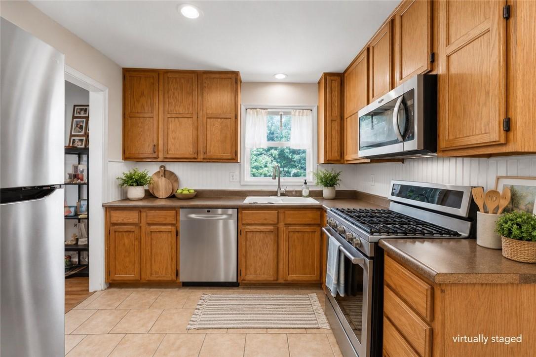 Image 2: Efficient kitchen featuring ample wood cabinetry,