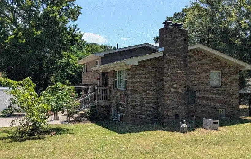 Image 1: Brick exterior, a prominent brick chimney