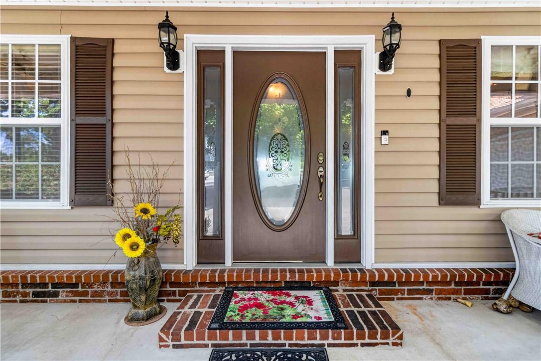 Image 3: Entryway featuring a brown door with an oval glass