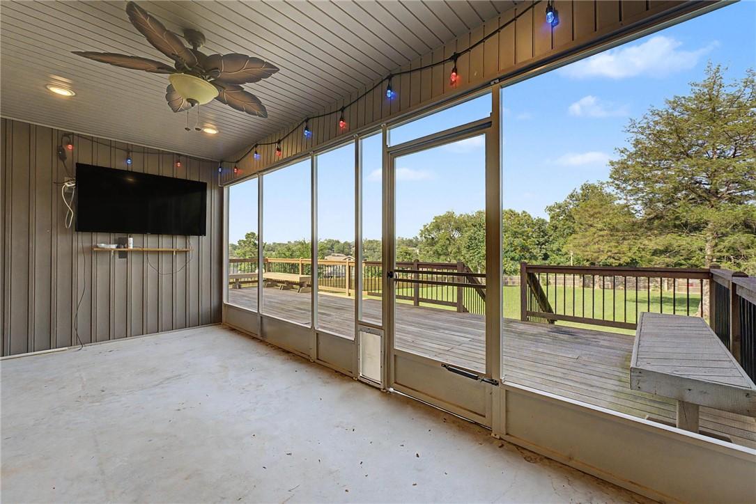 Image 3: Screened-in porch featuring a ceiling fan with lig
