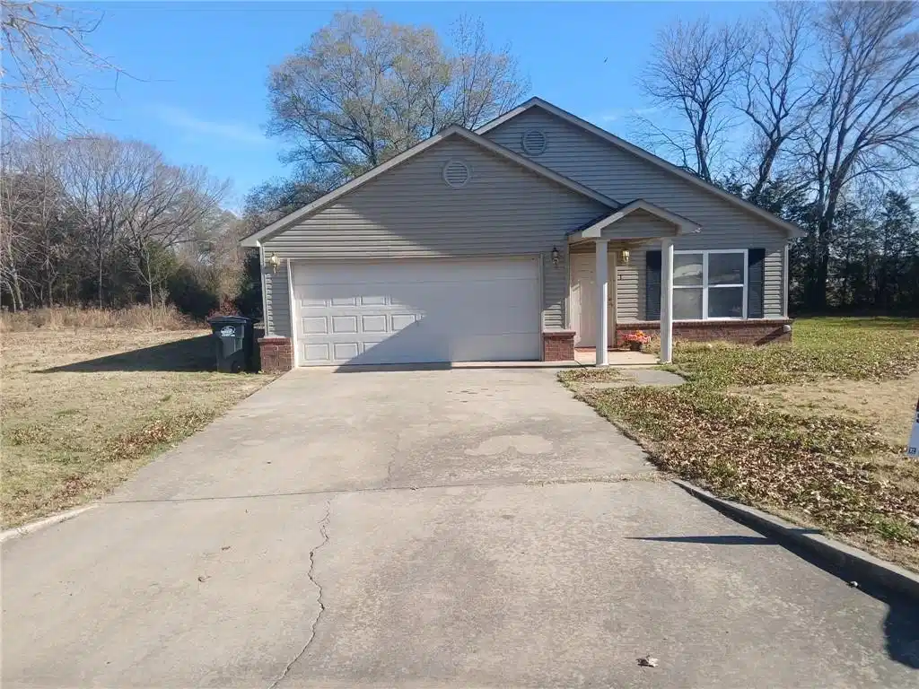 Image 1: Ranch-style house featuring brick siding, driveway