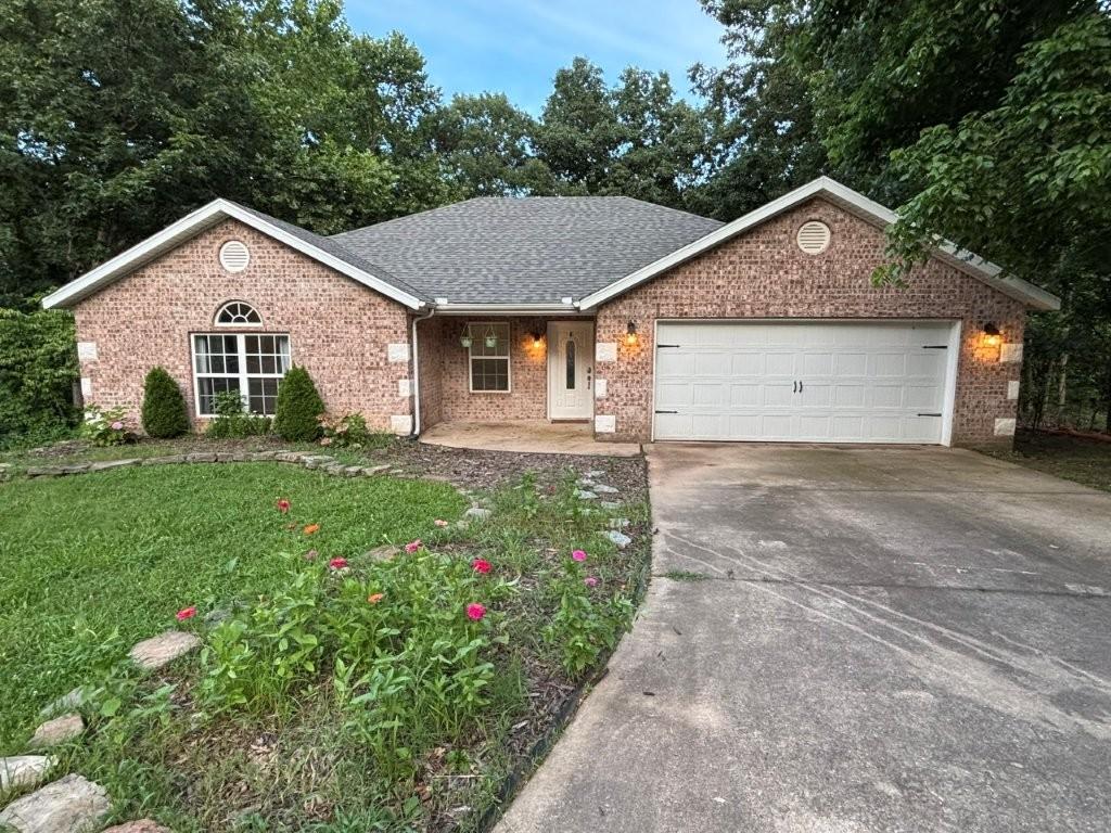 Image 2: Ranch-style house with concrete driveway, covered