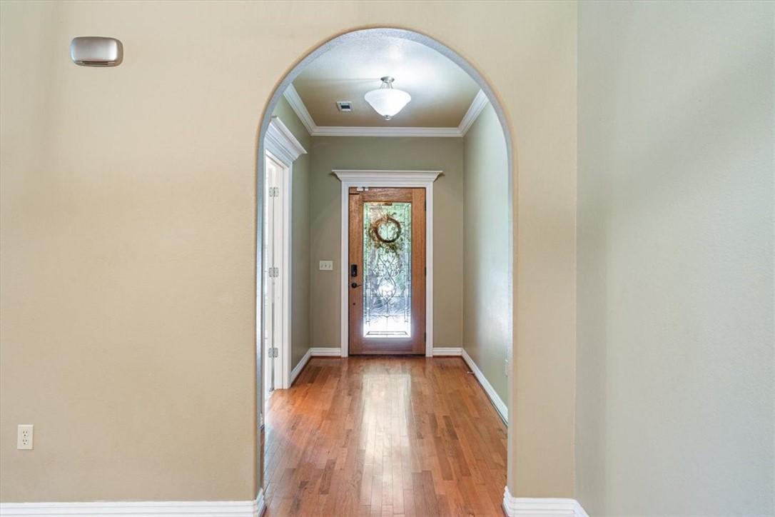 Image 3: Doorway featuring arched walkways, crown molding,