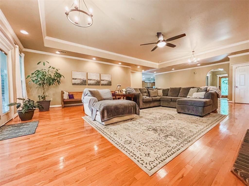 Image 4: Living area with a tray ceiling, a chandelier, arc