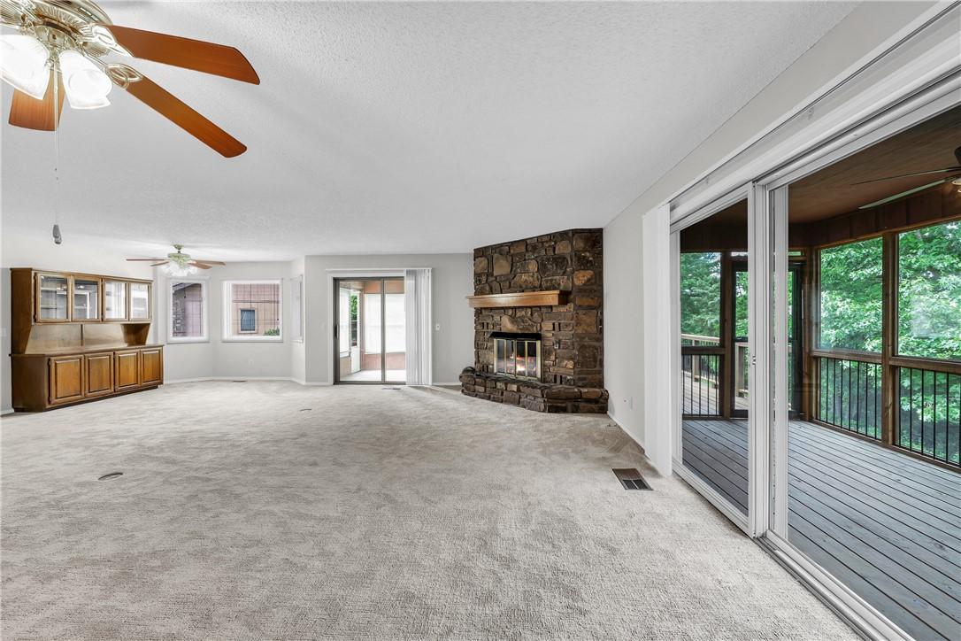 Image 3: Spacious interior featuring a stone fireplace with