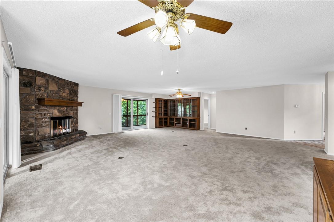 Image 4: Spacious living area featuring a stone-clad firepl