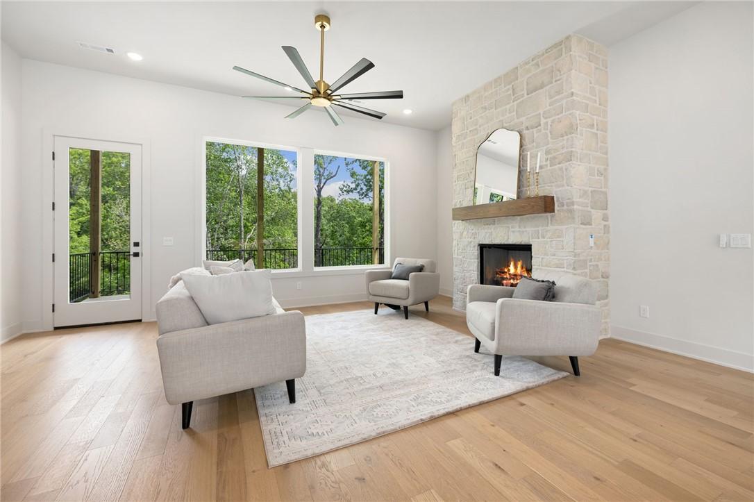Image 4: Living area featuring a stone-clad fireplace with