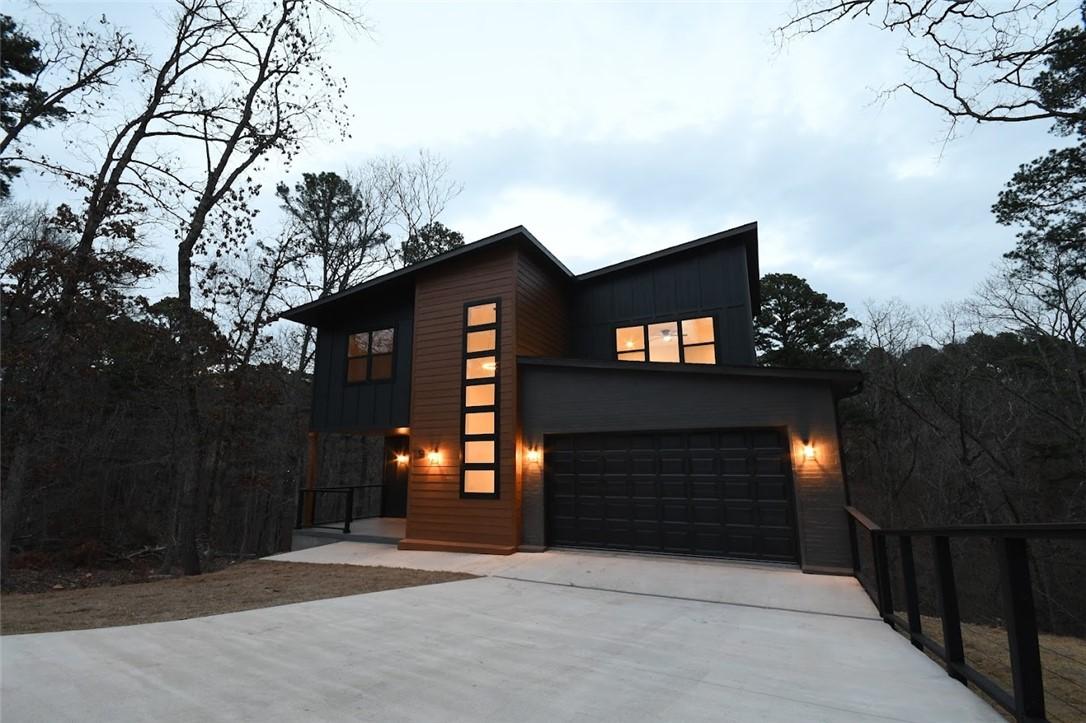 Image 1: Modern home with concrete driveway, board and batt