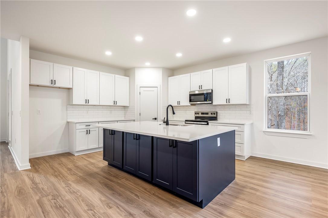 Image 4: Kitchen featuring white cabinets, a kitchen island