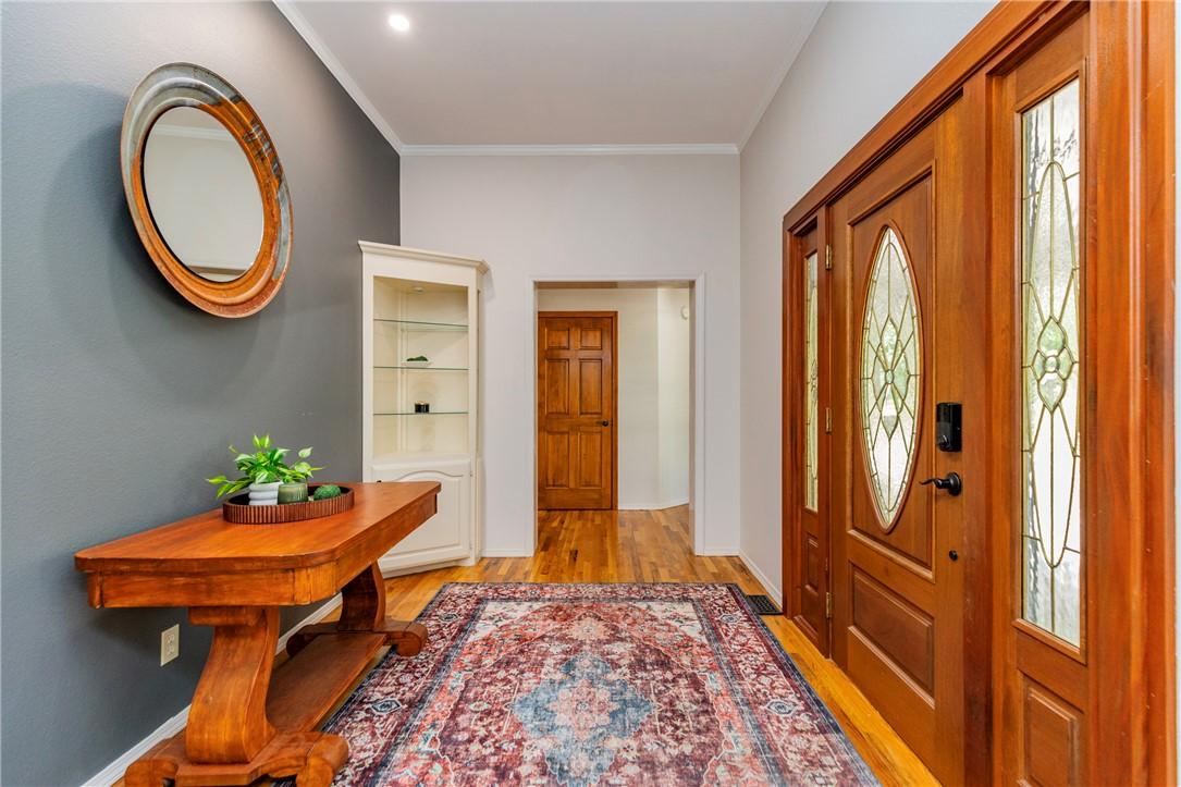 Image 2: Entryway featuring a wood-finish door with decorat
