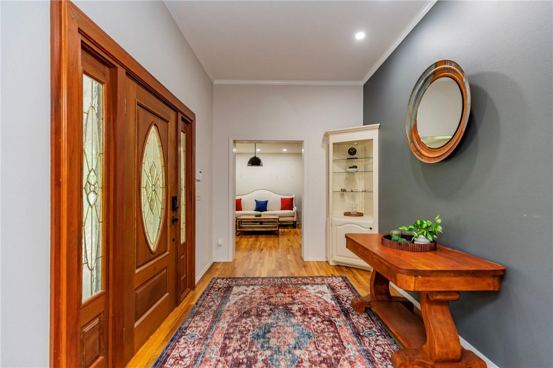 Image 3: Entryway featuring a wood-finish door with decorat