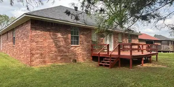 Image 2: Back of house featuring a lawn, a wooden deck, and