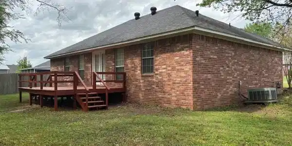 Image 4: Back of house featuring brick siding, a lawn, and