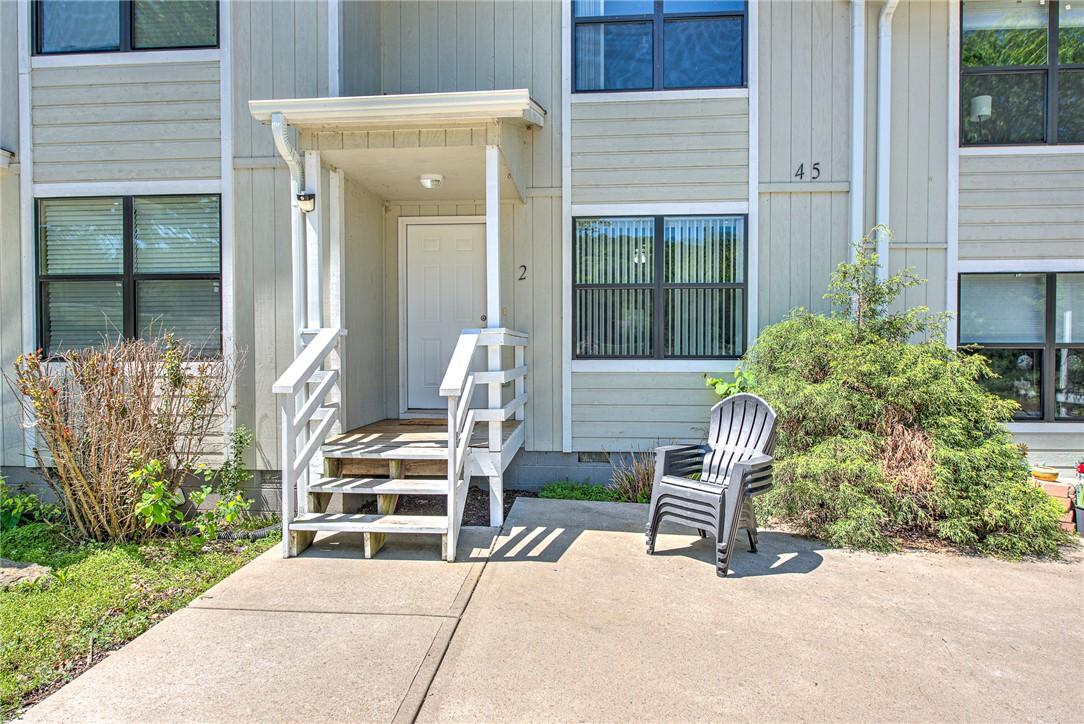 Image 2: Entryway featuring a covered porch, wood steps wit