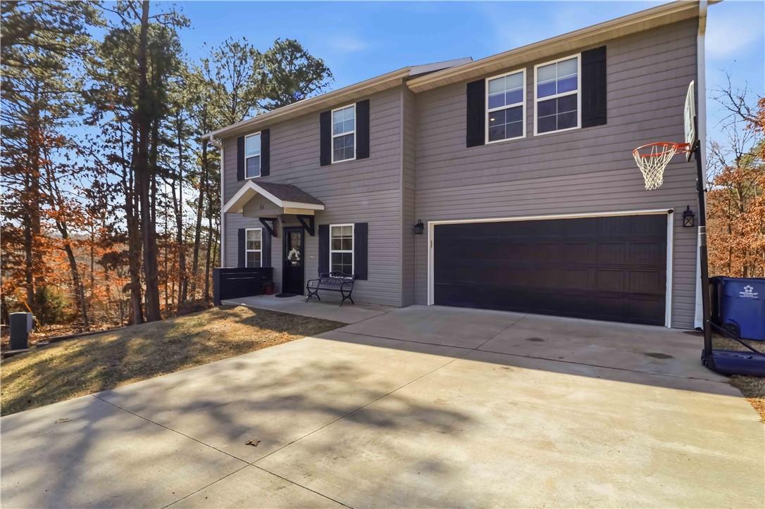 Image 2: View of front of home featuring a garage and drive