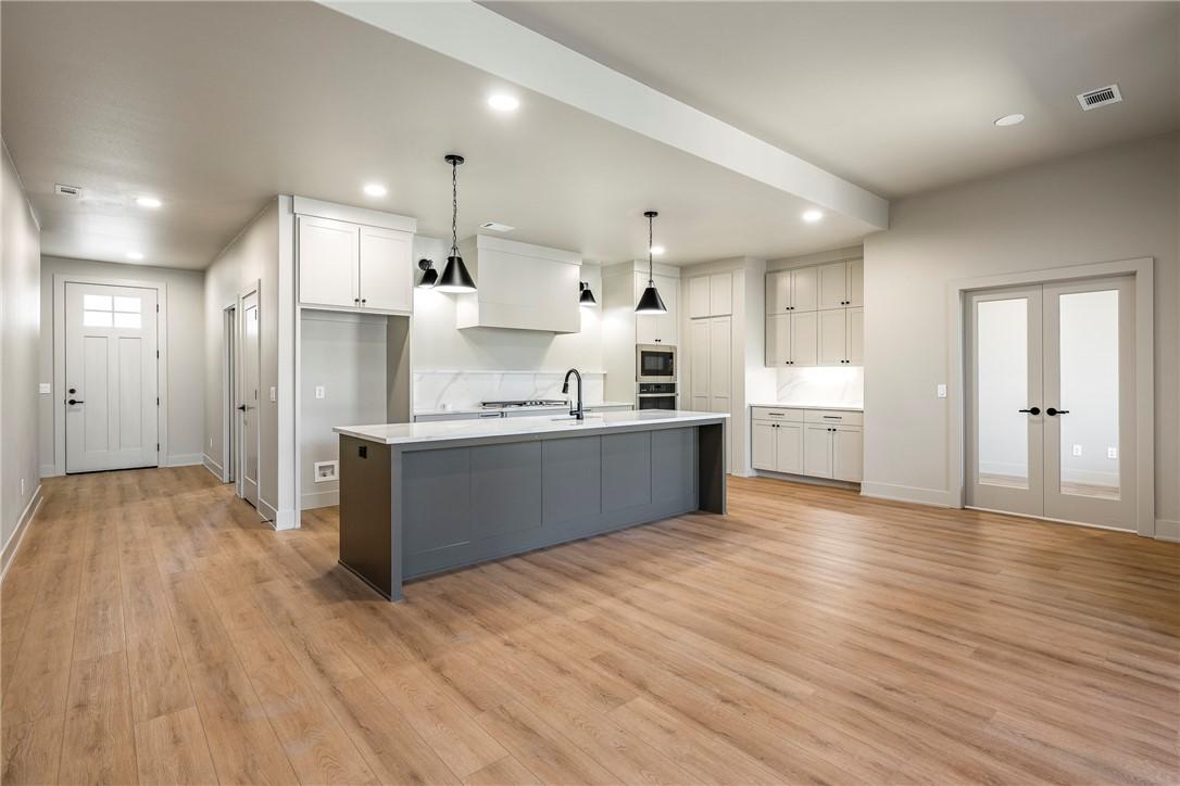 Image 3: Two tone kitchen with hanging light fixtures, dual