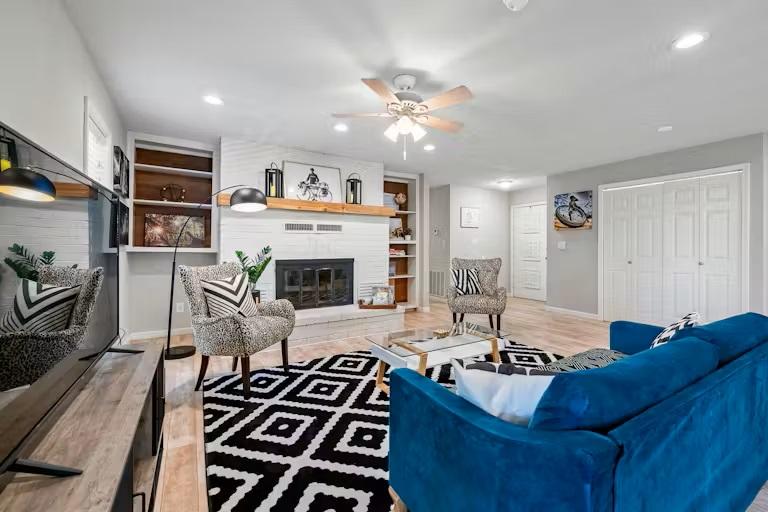 Image 3: Living area with ceiling fan, built in shelves, a