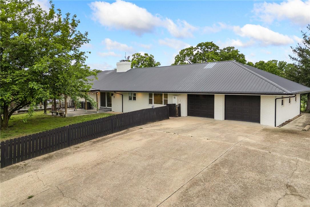 Image 2: White brick exterior featuring a dark metal roof,