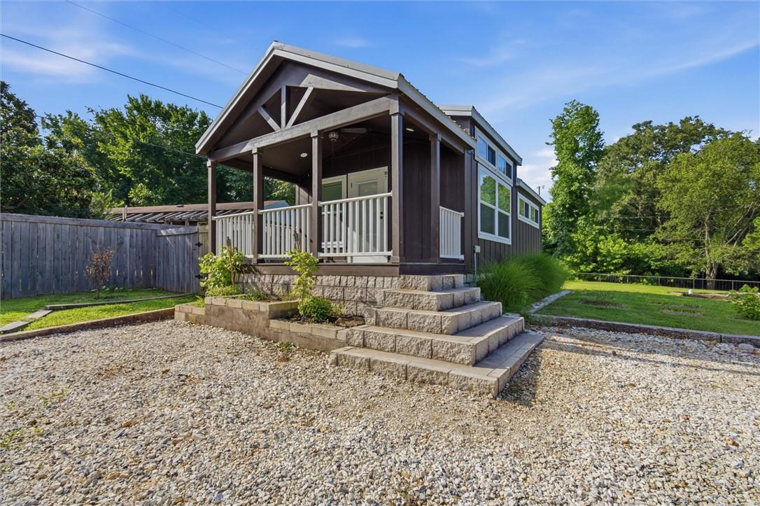 Image 3: Wood-sided exterior with white trim and a covered