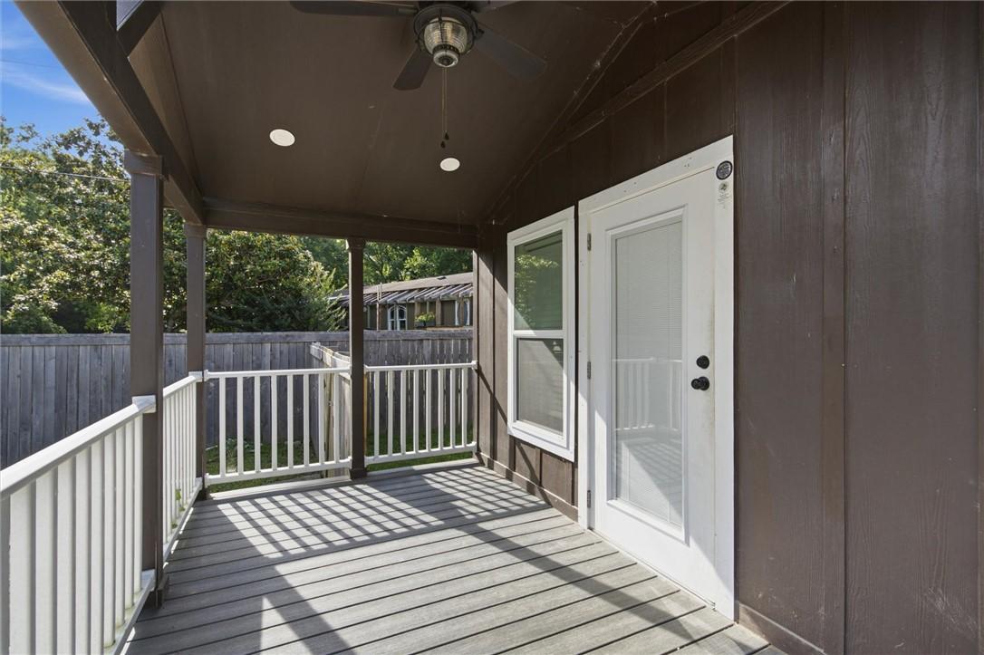 Image 4: Covered outdoor deck with white balustrade and pla
