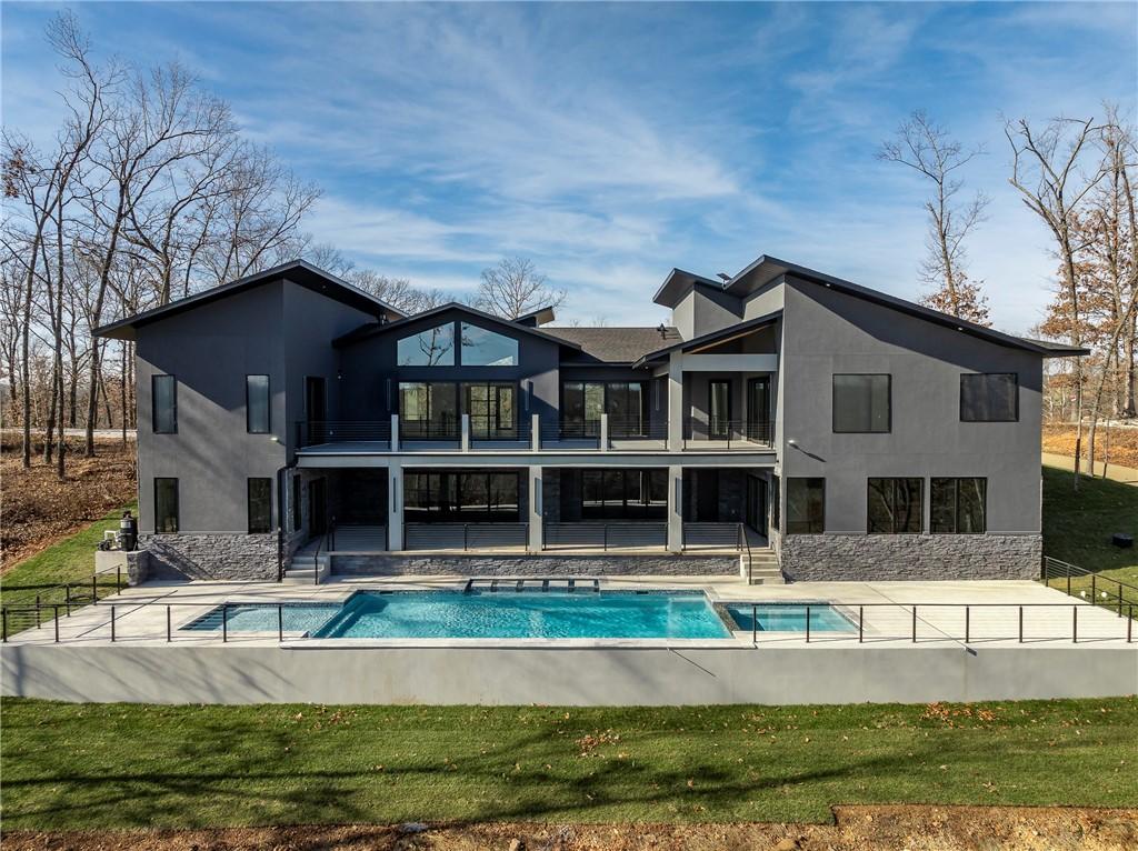 Image 1: Back of house with a patio area, a balcony, a pool