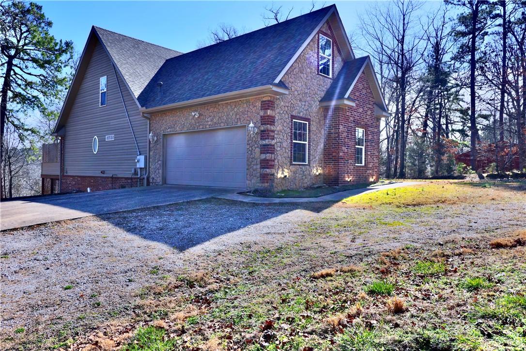 Image 2: View of side of home featuring concrete driveway,