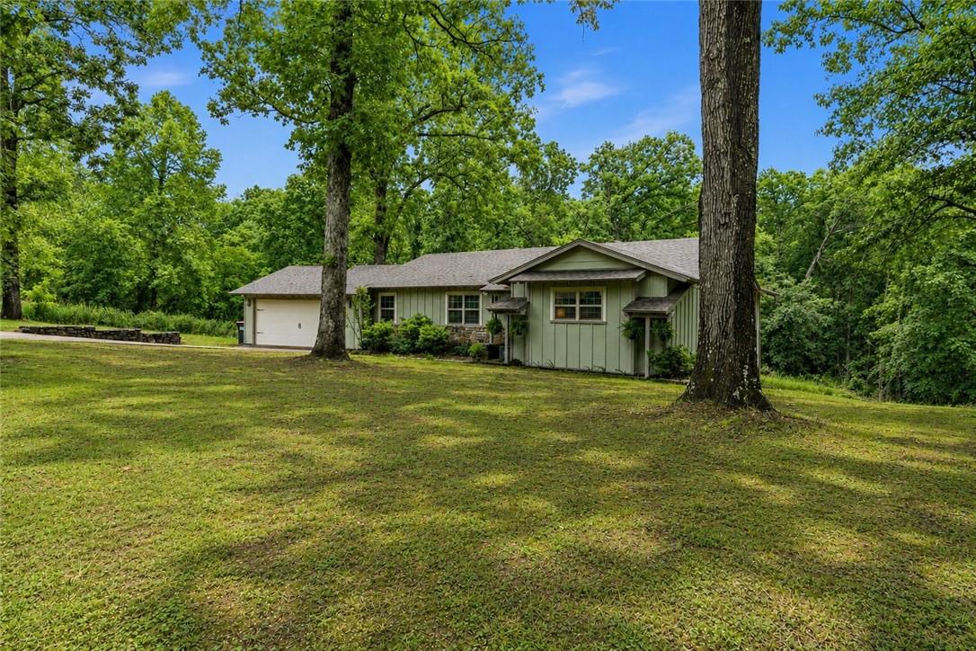 Image 3: Expansive green lawn with mature trees and a singl