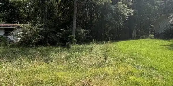 Image 4: Expansive lot featuring mature trees and varied gr