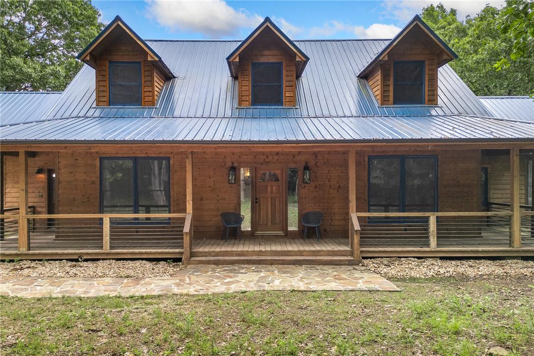 Image 2: Wood-sided exterior featuring a covered porch, a m