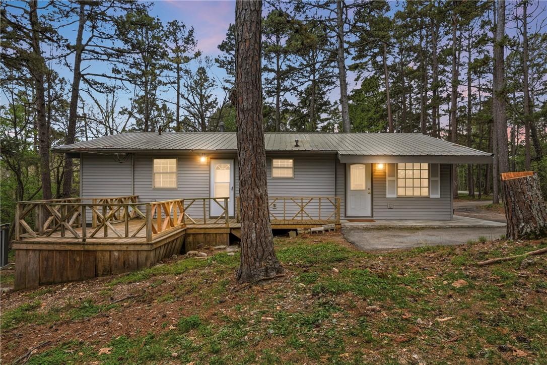 Image 2: Back of house at dusk featuring a metal roof, a wo