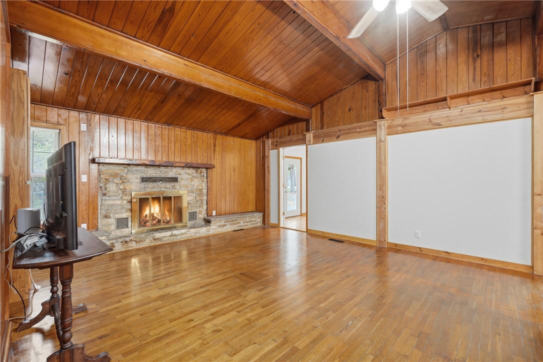 Image 3: Unfurnished living room with wooden walls, light w