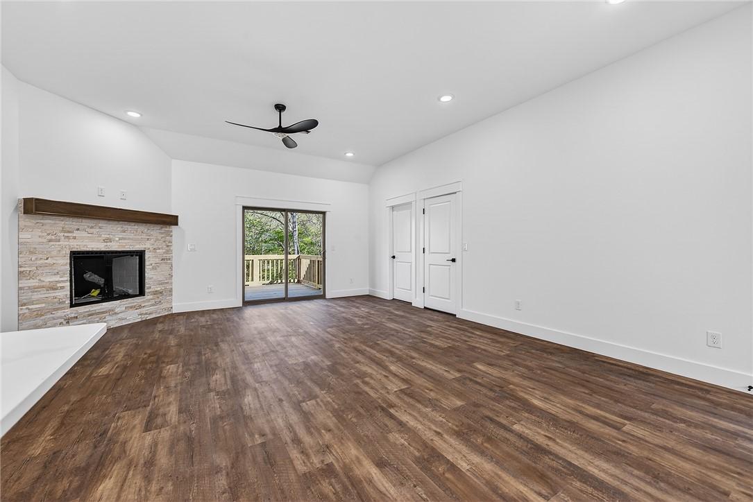 Image 3: Unfurnished living room featuring a stone fireplac
