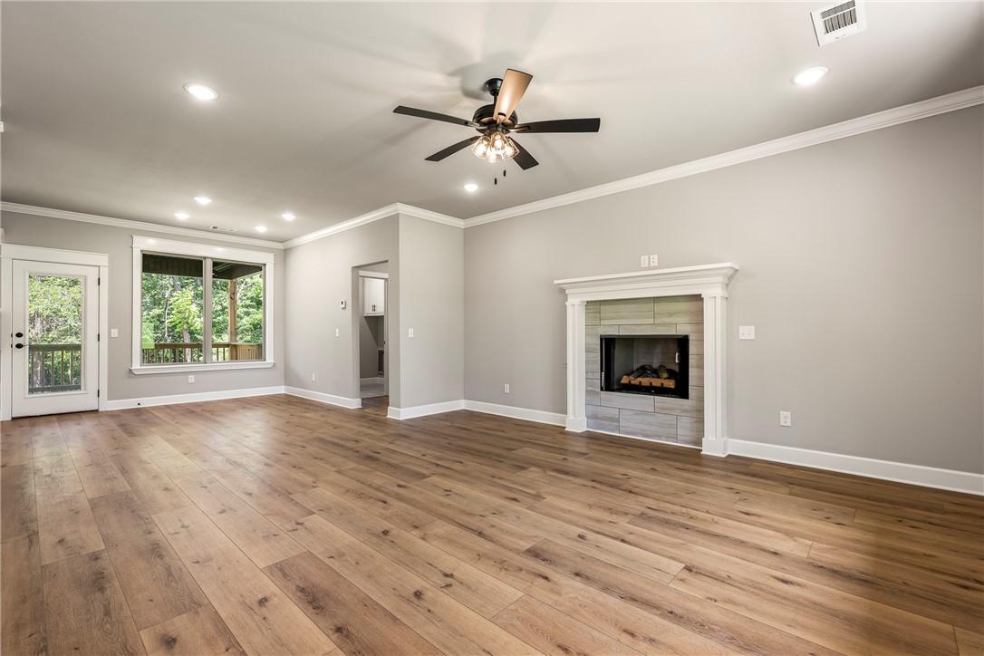 Image 3: Spacious room featuring wood-finish flooring, a ti