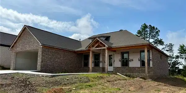 Image 2: Brick exterior with dark shingle roofing