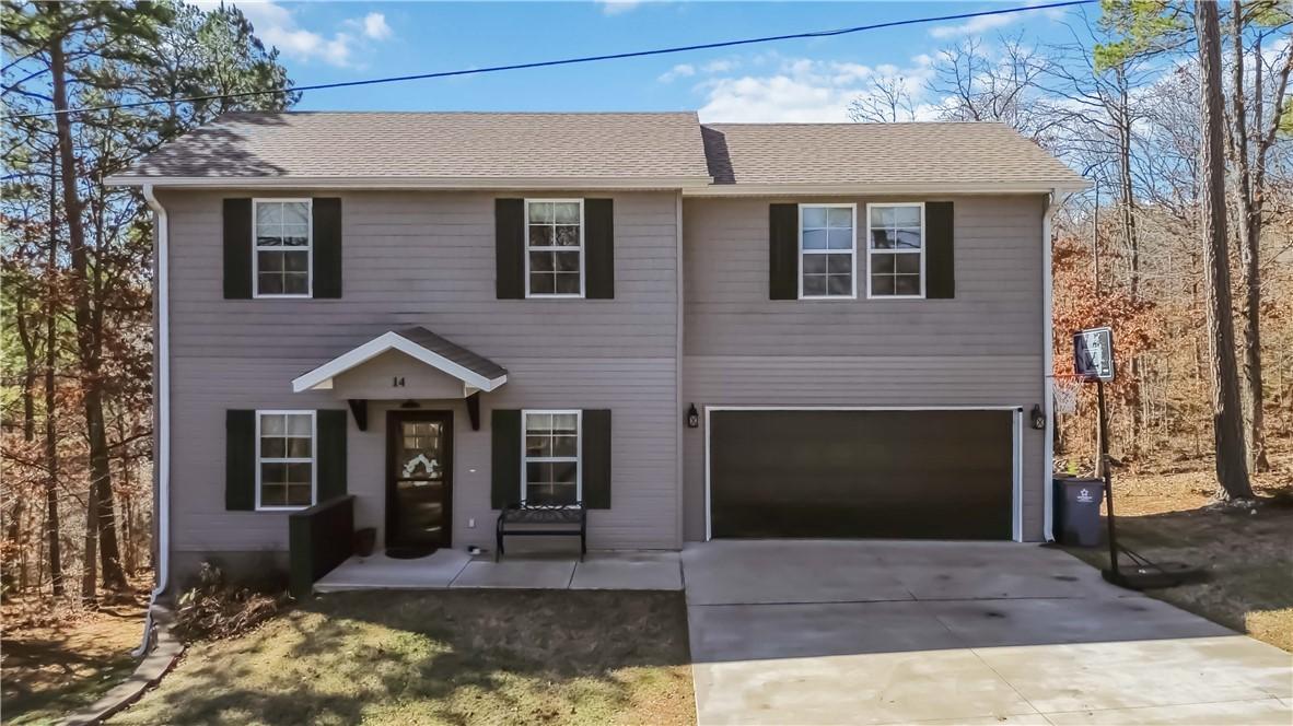 Image 1: View of front facade with an attached garage, conc