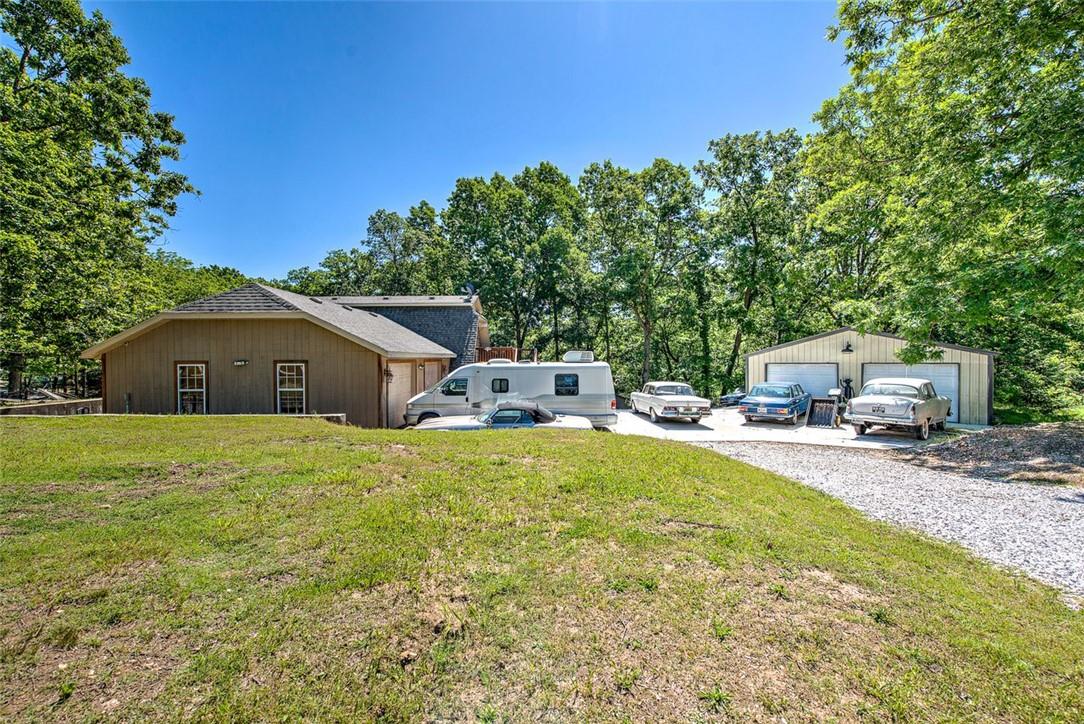Image 3: Expansive gravel driveway leading to a detached tw