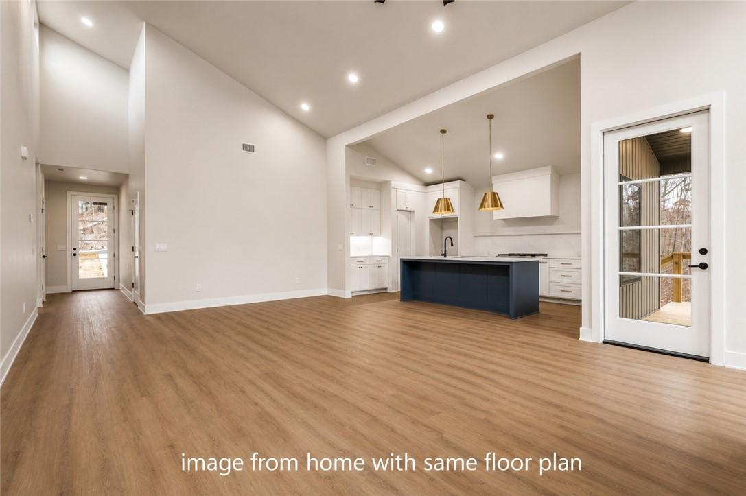 Image 2: Open-concept living space featuring wood-finish fl