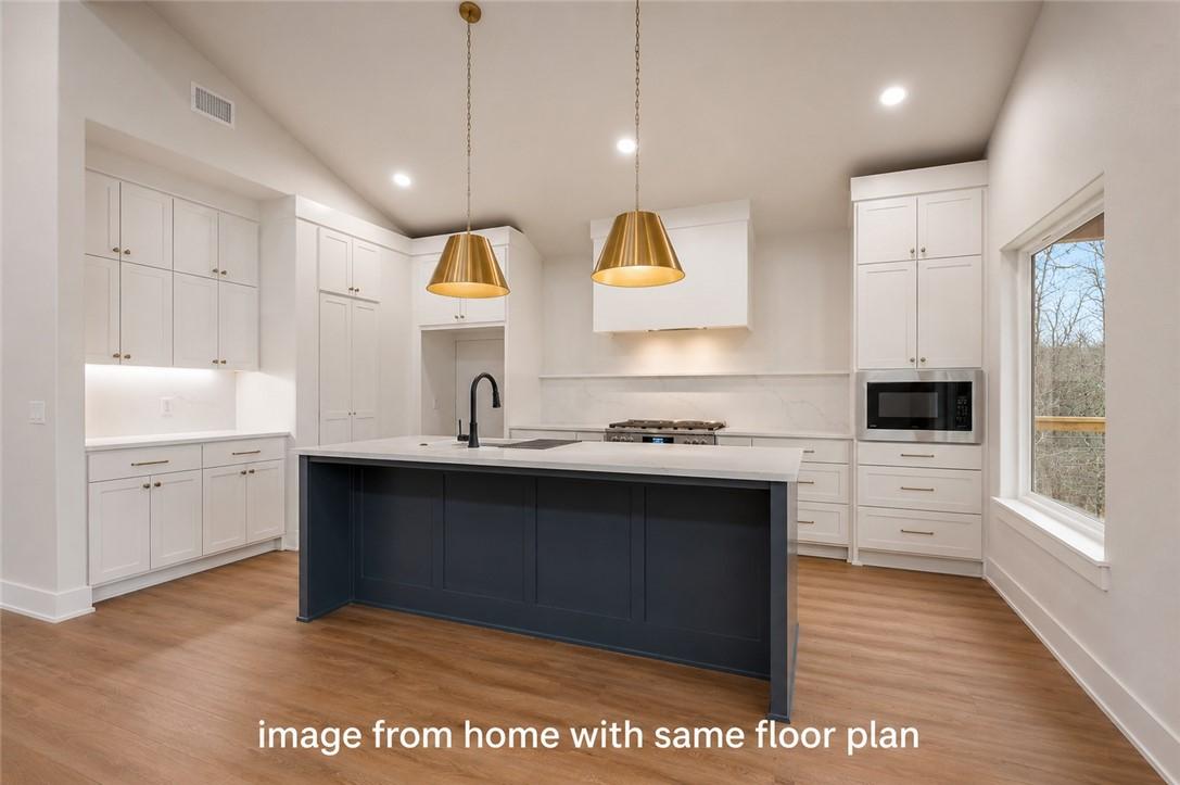 Image 4: Modern kitchen featuring a large island with a dar