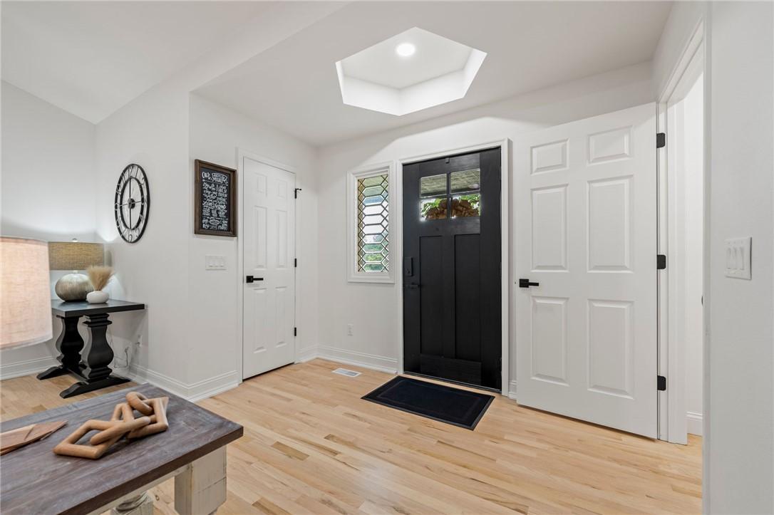 Image 2: Bright entryway featuring a black paneled door wit