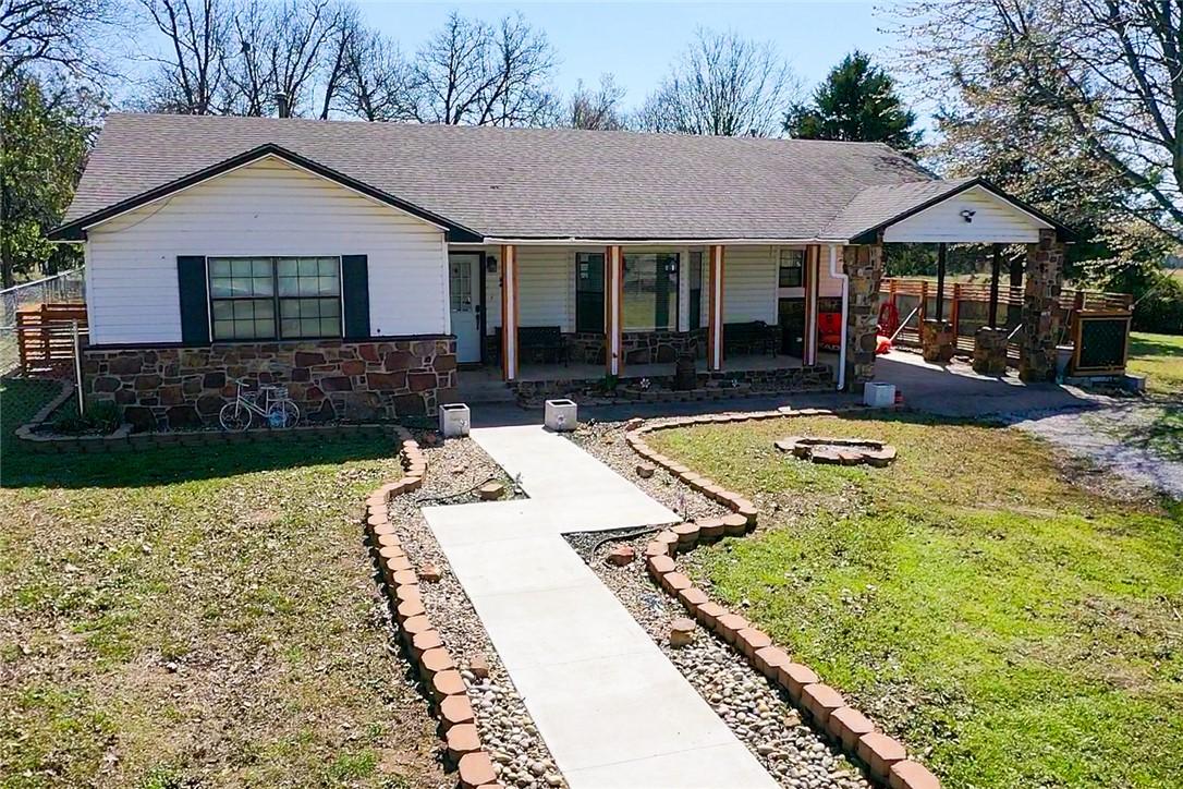 Image 1: Single story home with covered porch, stone siding