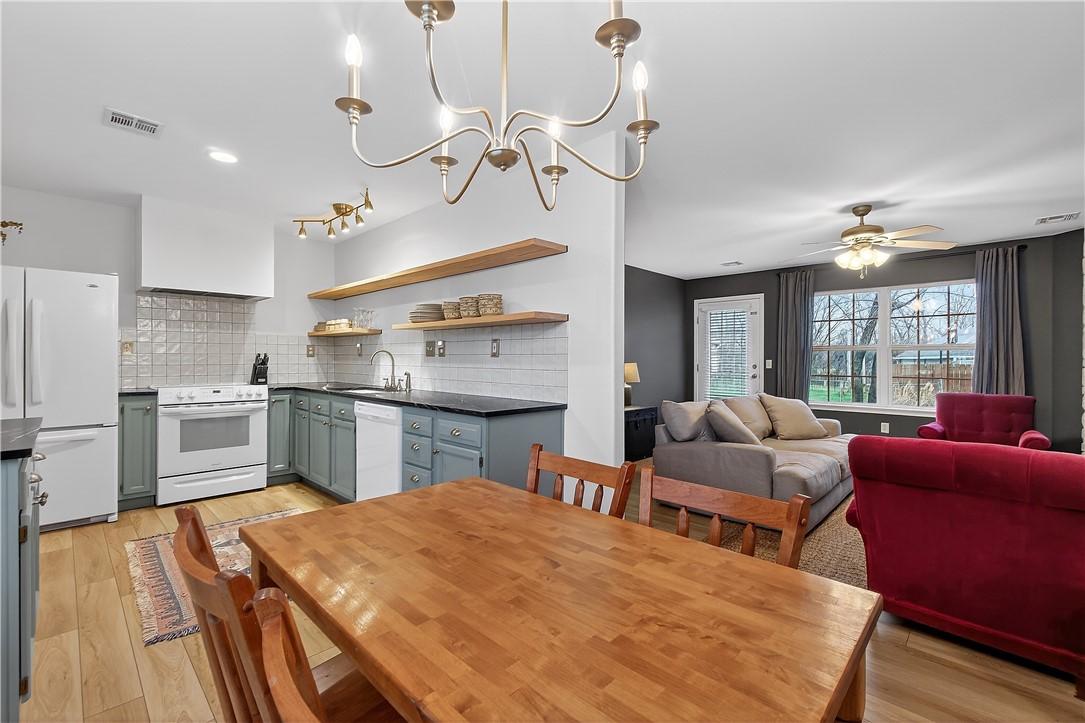 Image 4: Dining area with light wood-style floors, a chande