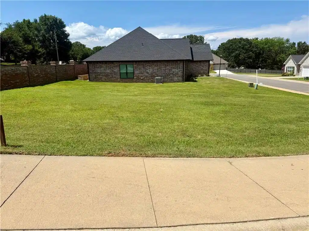 Image 1: Expansive green lawn surrounds a brick exterior re