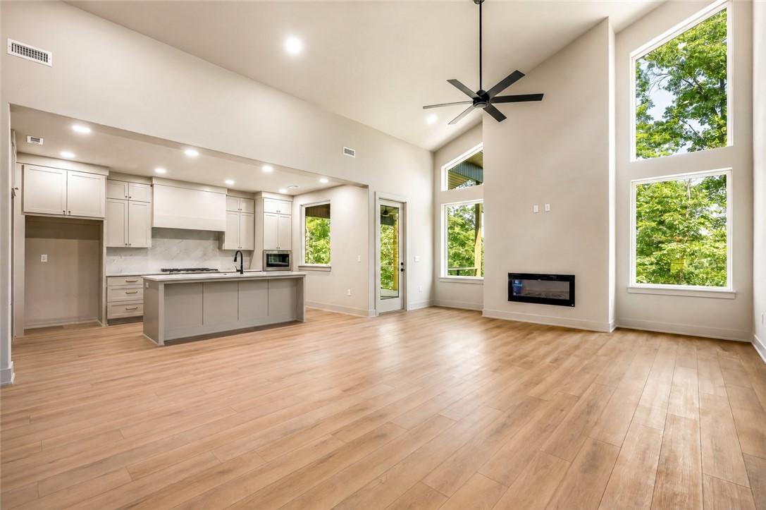 Image 2: Open-concept living area featuring high vaulted ce